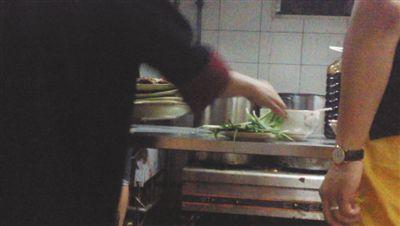 7月23日,漢麗軒烤肉超市昌平店,服務員將幾盤顧客剩菜(左手中疊在一起的是幾盤肉,其右手正整理韭菜)端回后廚,進行整理后準備再送往餐廳自助取餐區供顧客食用。